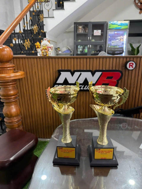Championship trophies of the TBS & Friends Badminton Tournament 2026 at NNB Badminton Club